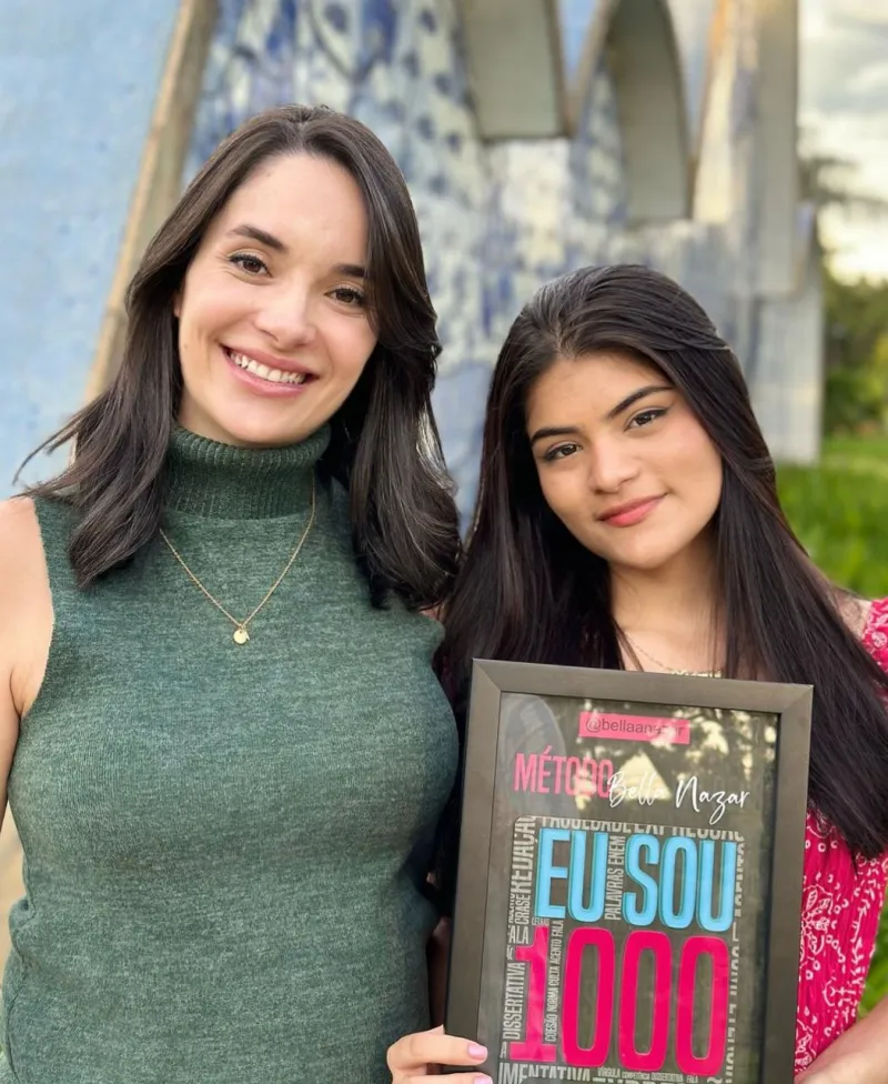 Bella Nazar com aluna segurando o quadro 