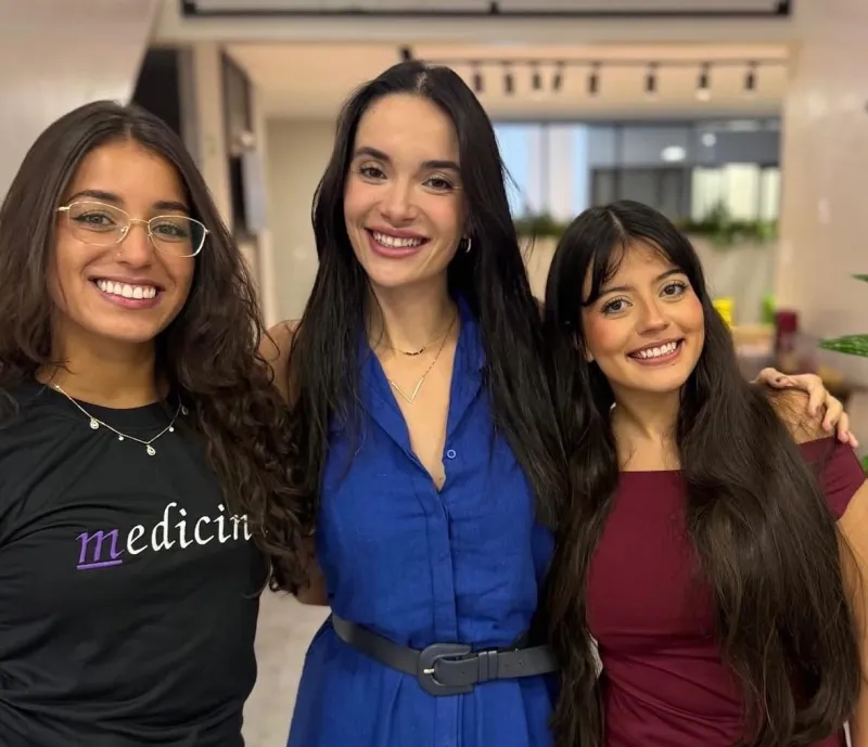 Bella Nazar com duas alunas, uma de camiseta de Medicina